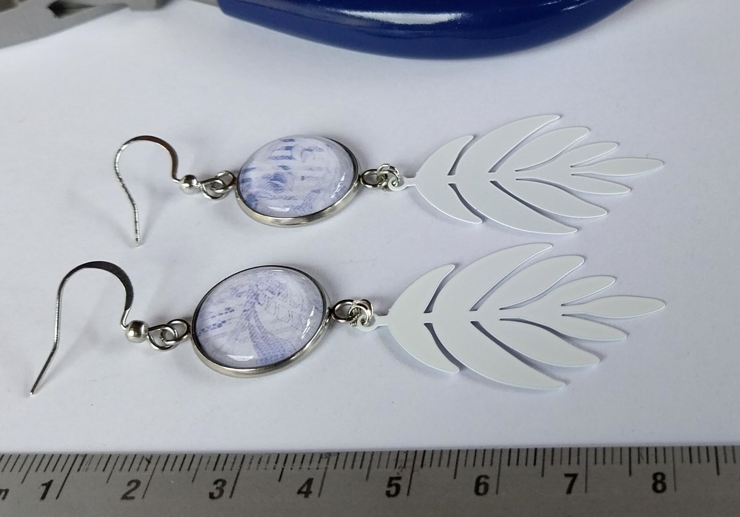 Boucles d'oreille cabochons bleus et blancs et breloque feuille blanche