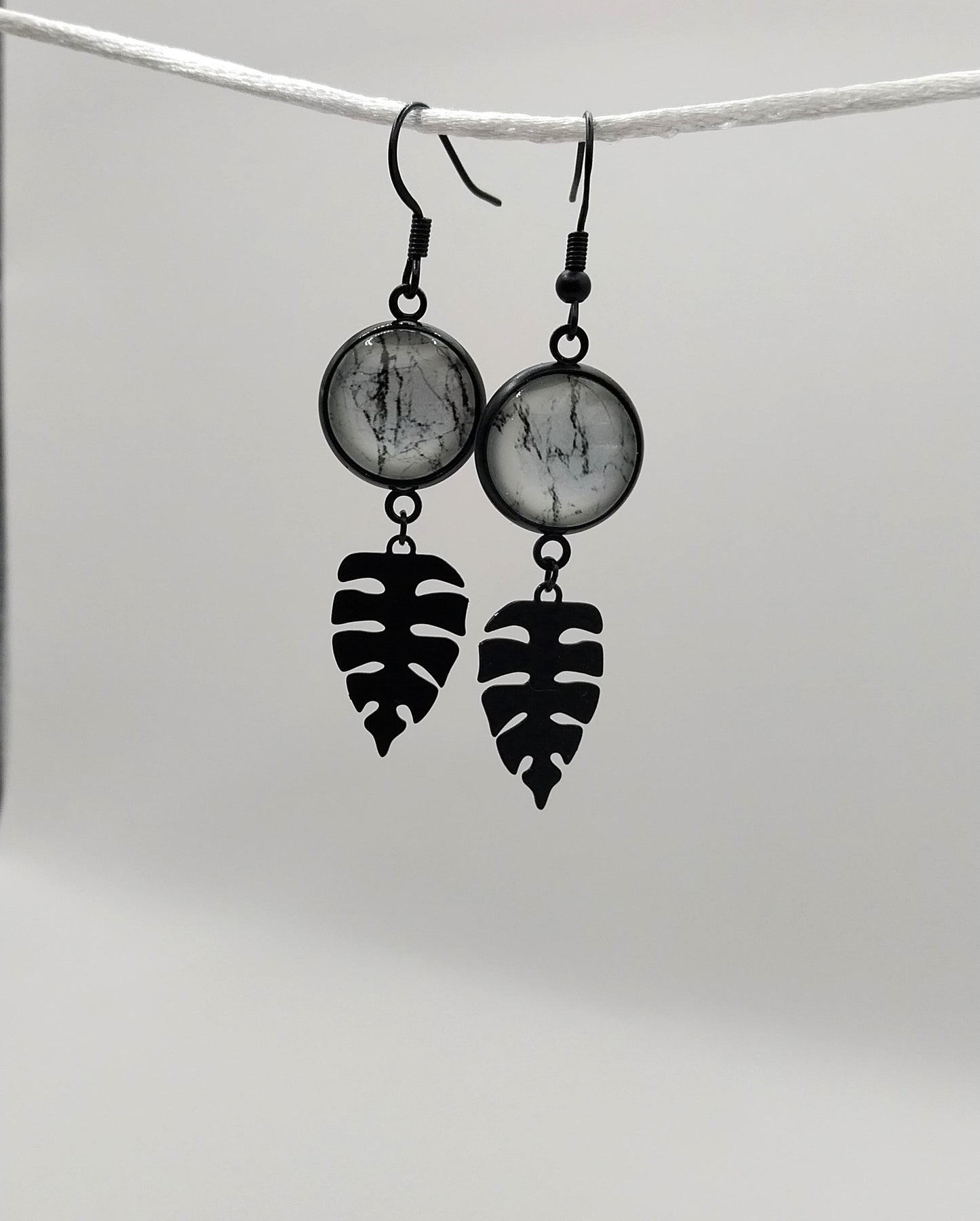 Boucles d'oreille cabochon  marbré noir et blanc et breloque feuille tropicale