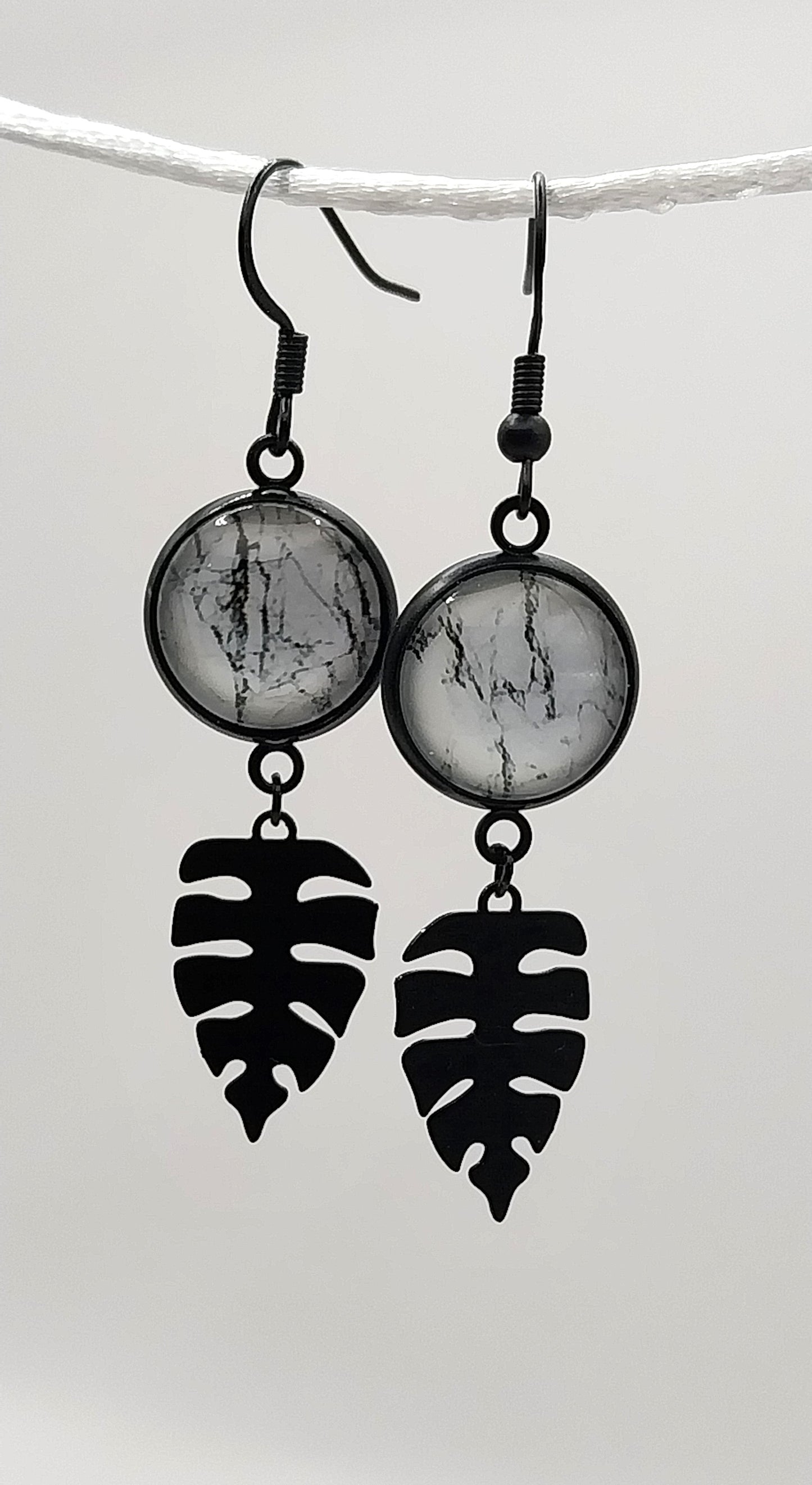 Boucles d'oreille cabochon  marbré noir et blanc et breloque feuille tropicale